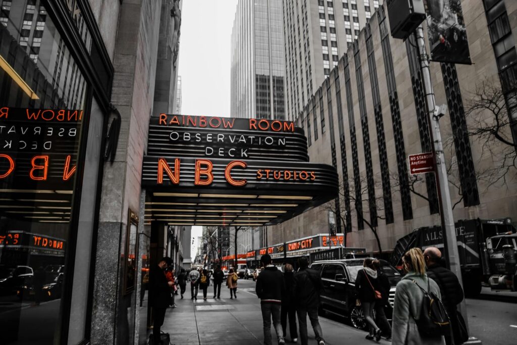 NBC Studios entrance at Rockefellers Center New York with street view showing NBC News headquarters and its influence on US Finance and stock market trends 