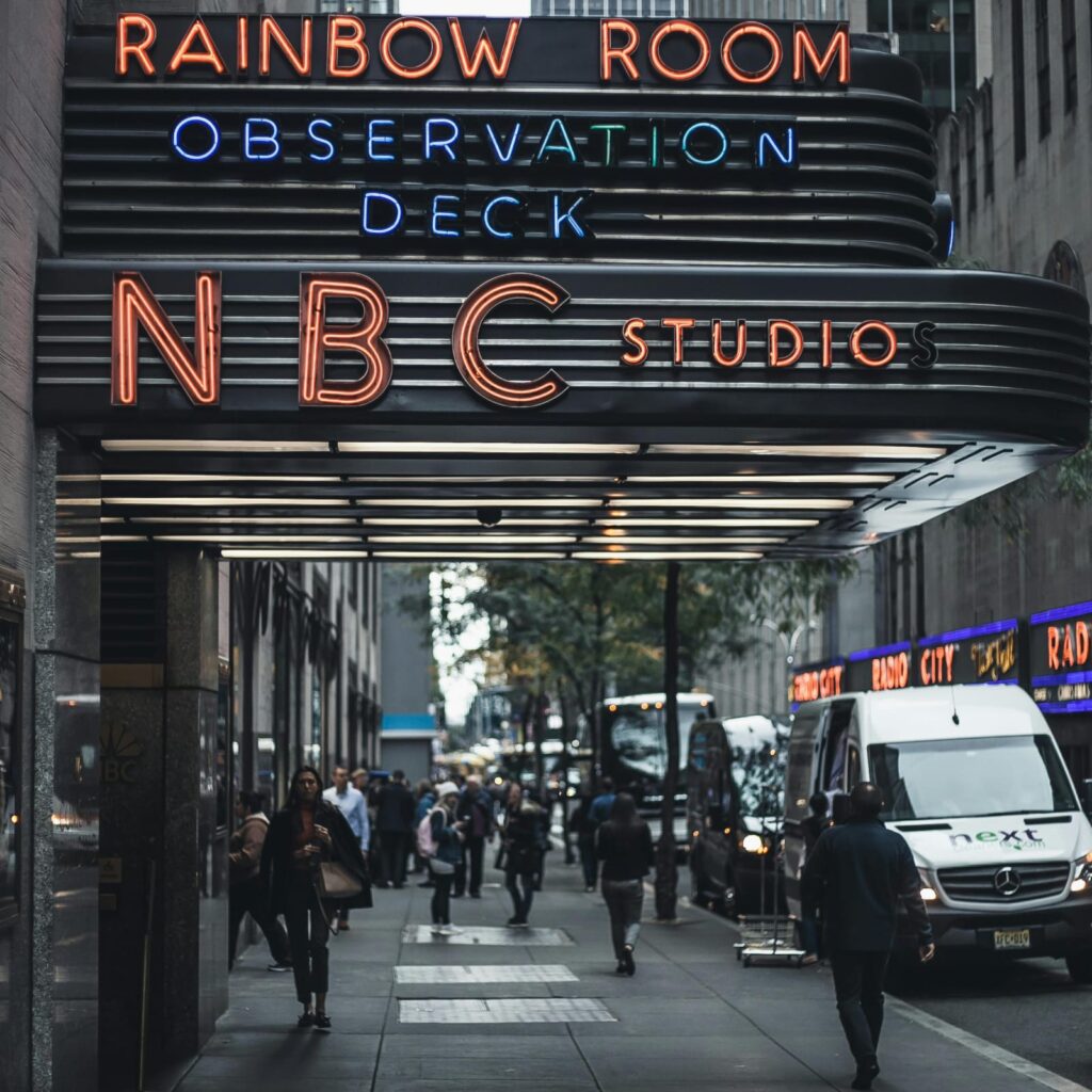 NBC Studios entrance at Rockefellers Center with Rainbow Room sign in New York showing NBC News headquarters and its influence on US finance and stock market trends 