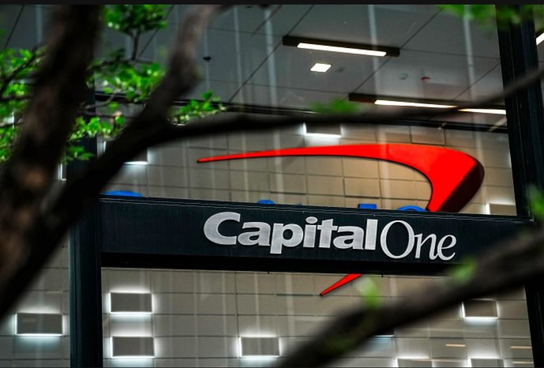 An official capital one building entrance with the red and blue logo visible behind the glass. This is the headquarters involved in the $425 million 360 savings class-action settlement claim process.